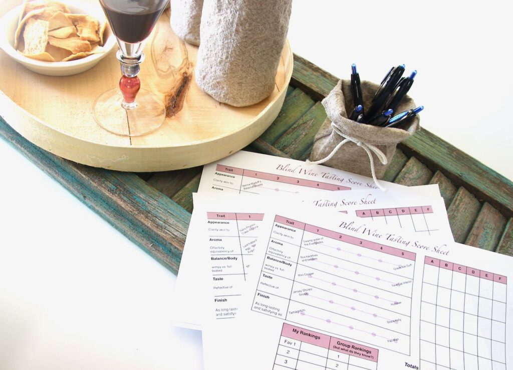 wine tasting scorecards with pens and other party supplies on a tray