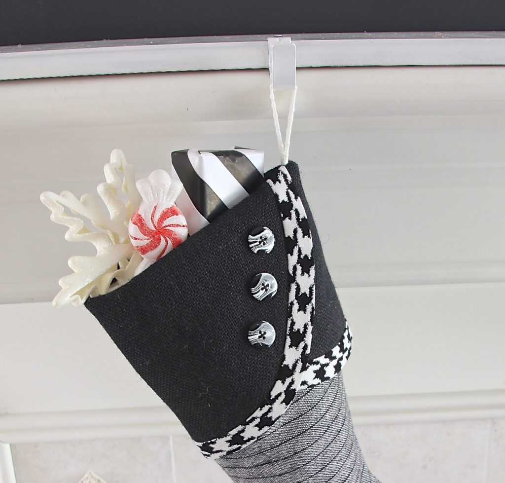 black & white Christmas stocking hanging from white mantel