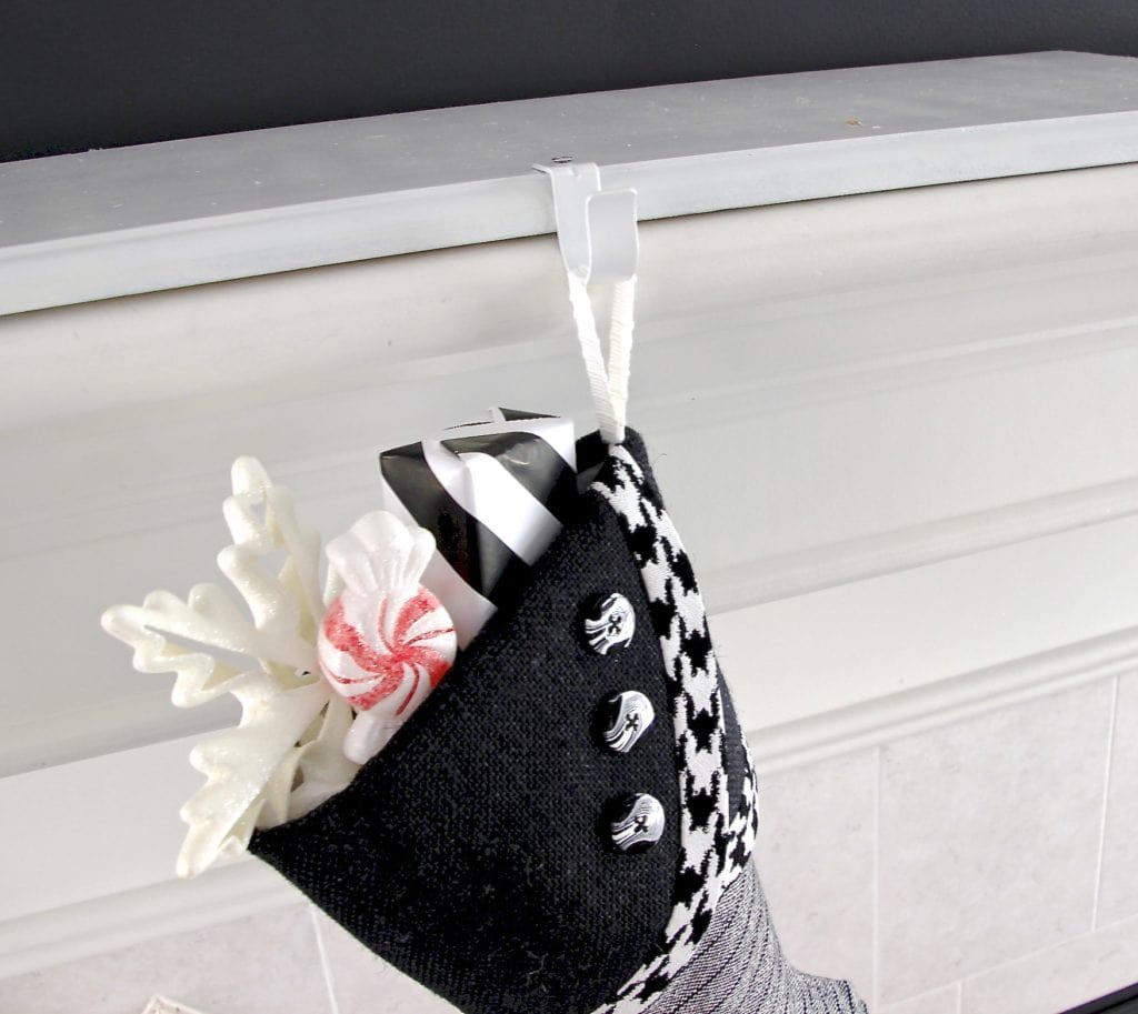 black and white christmas stocking stuffed with a snowflake, faux peppermint and wrapped present