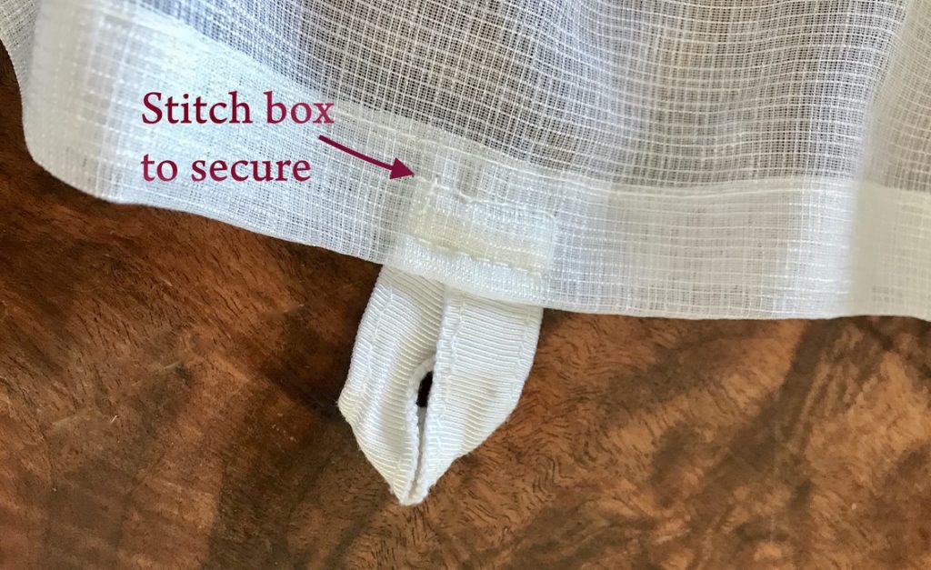 Closeup of secured ribbon with a stitched box