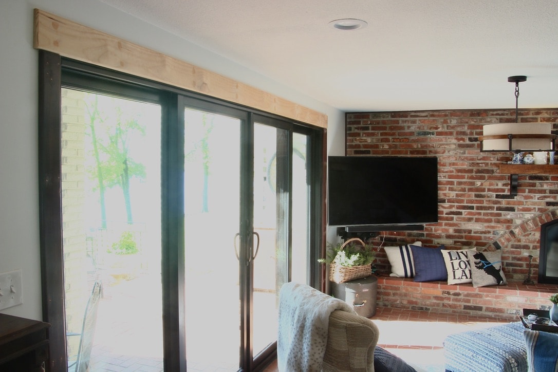 Wall of Glass window and sliding doors with a tv on the adjoining brick wall