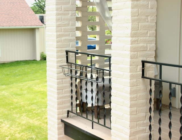 an empty iron railing planter hanging on an iron balcony railing