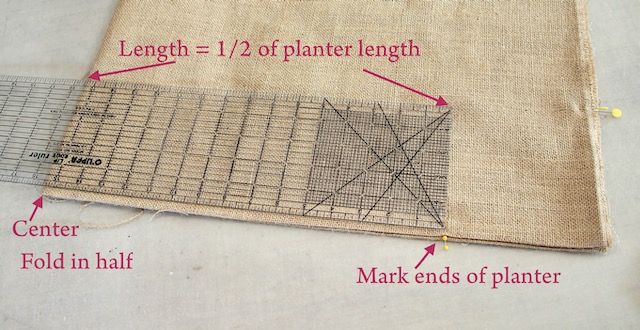 folded piece of burlap with a ruler on top and spots marked