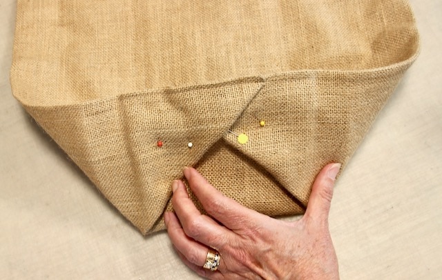 woman's hand holding the end of the custom planter liner with a pin