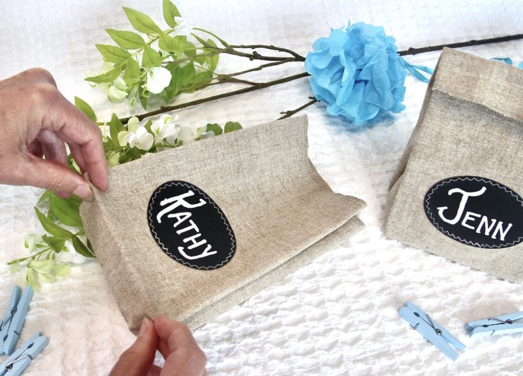 Finger pressing the front base of the personalized linen party favor bags