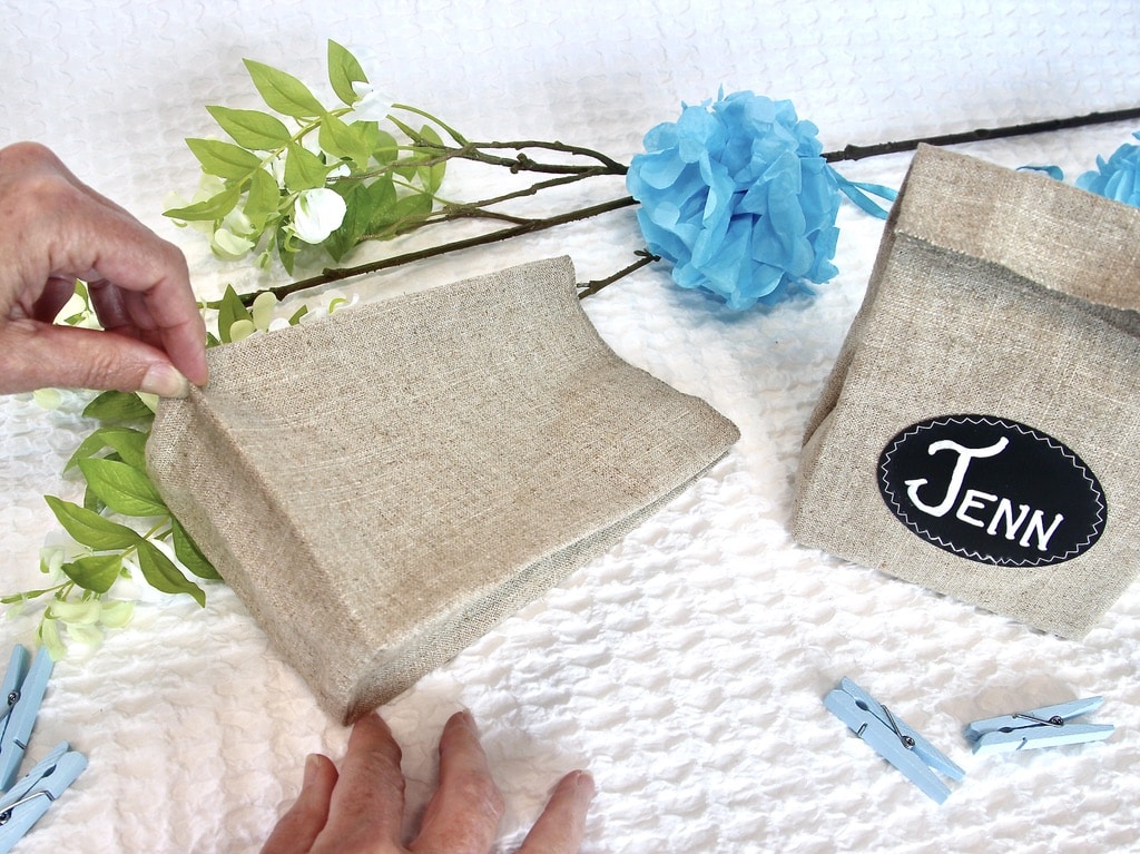Finger pressing the back base of the personalized party favor bags