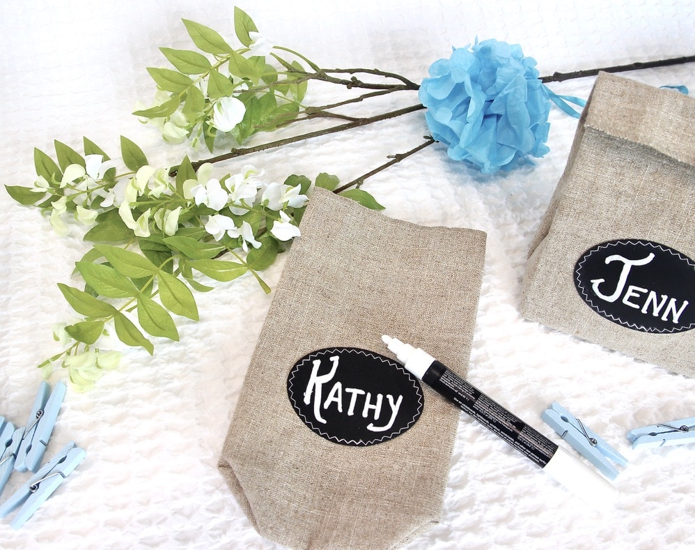Personalized Party Favor Bags with names being written on the chalk cloth labels.