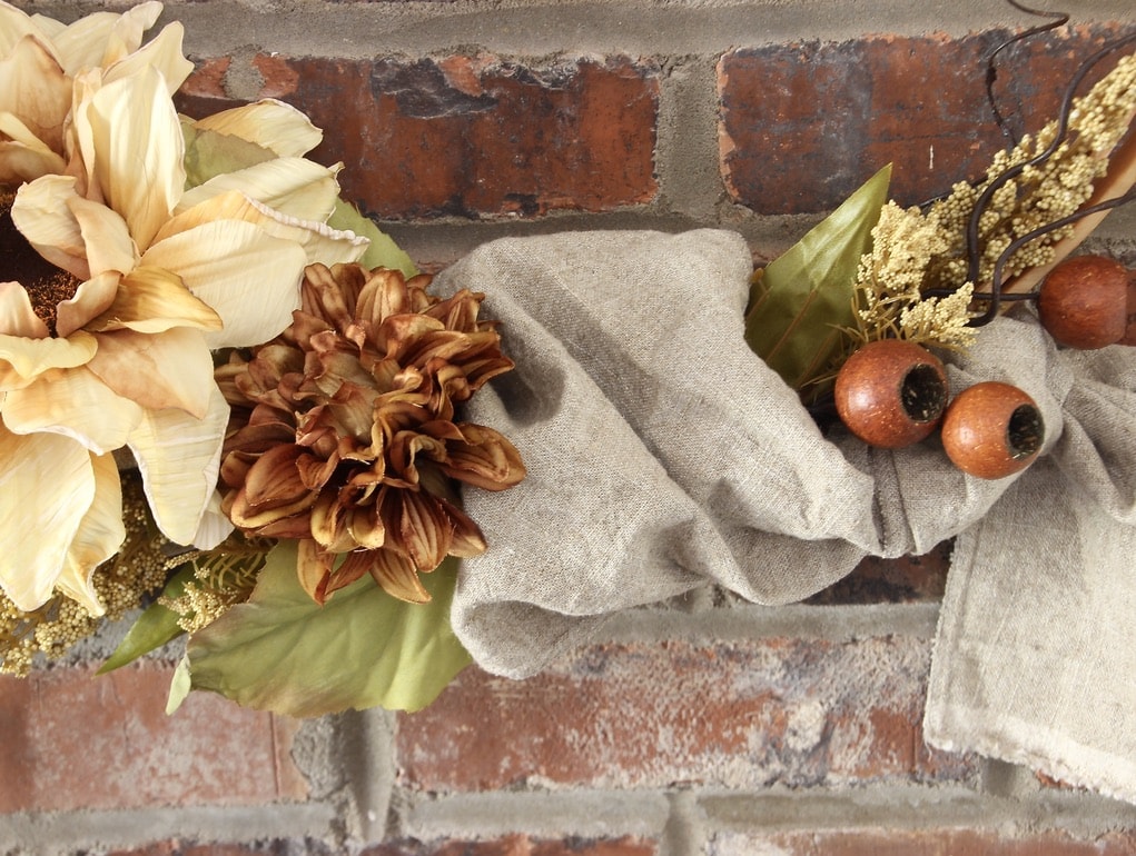 Closeup of table runner woven into wreath on brick wall