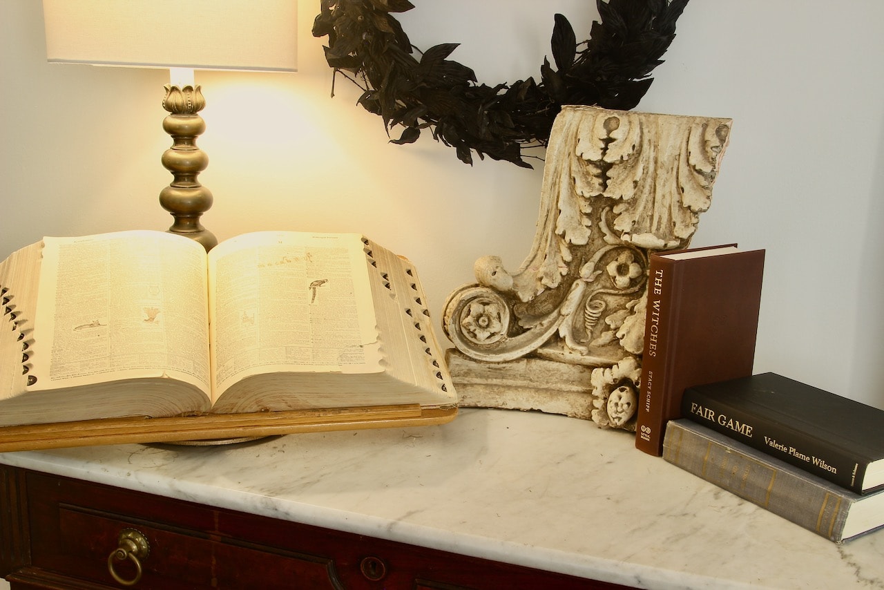 Three hardback books stacked next to architectural salvage 