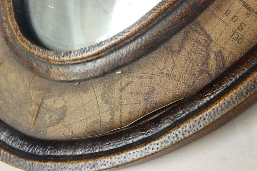 Closeup of the edge of the original thrifted mirror showing the map decal