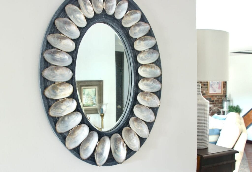 shell mirror hanging on wall with the corner of adjacent room showing on the right