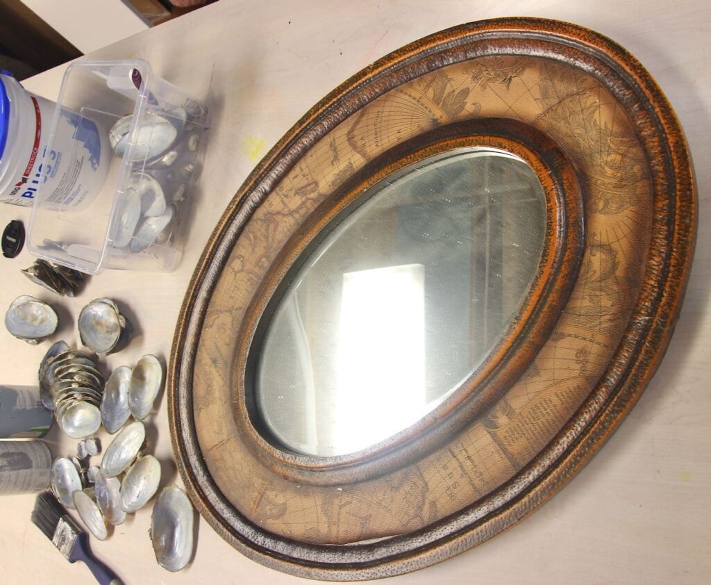 Brown Oval mirror with a pile of washed shells