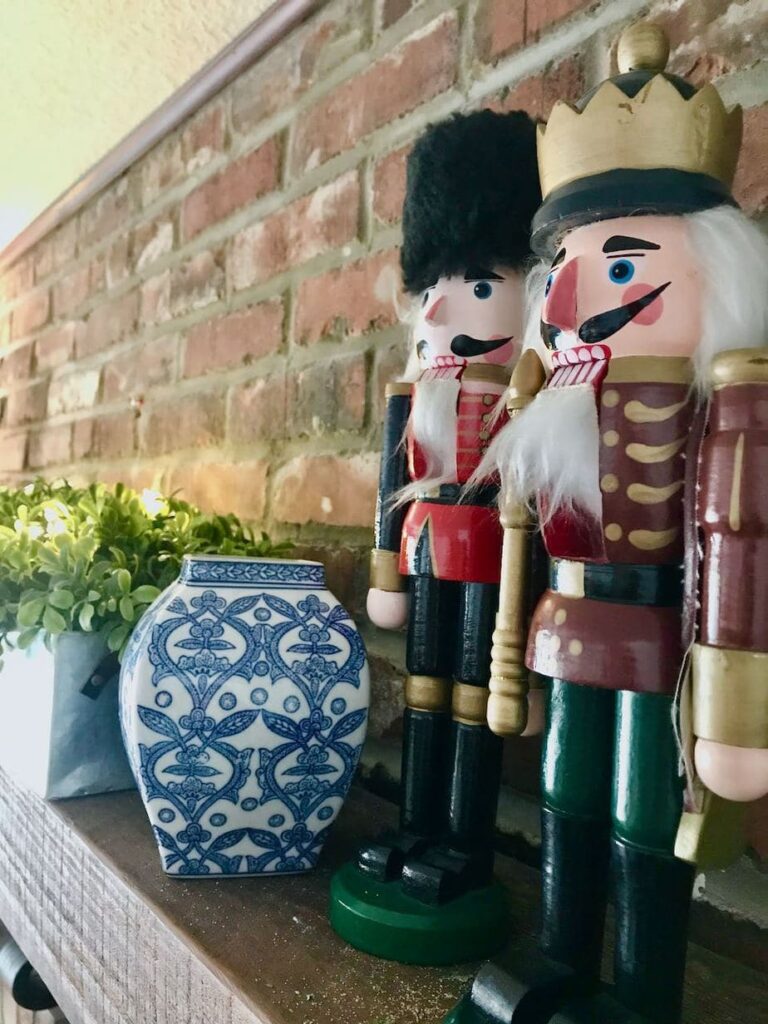 Woode Nutcrackers with blue and white pottery on brick fireplace mantel