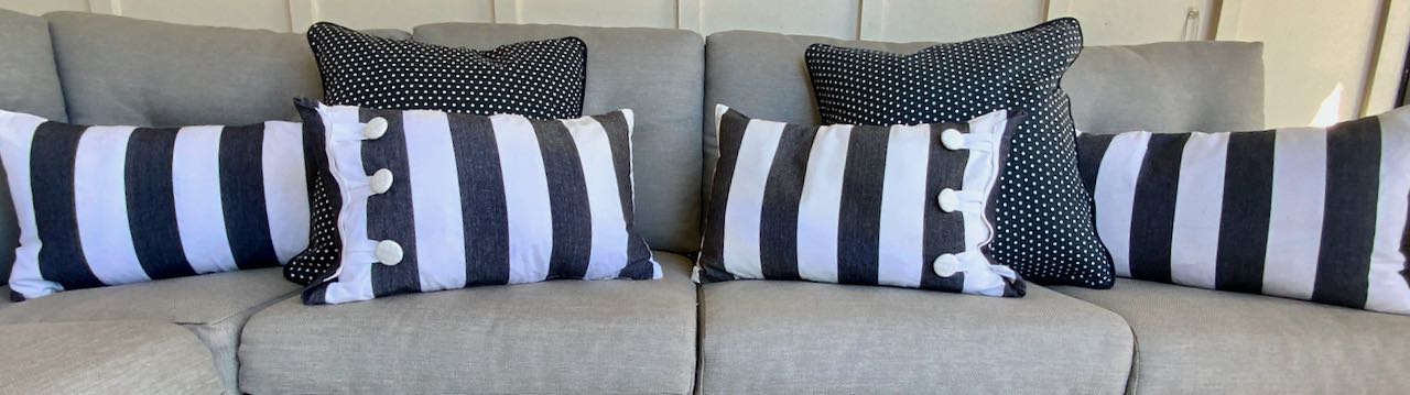 wide picture of four cabana stripe pillows with two polka dot pillows on an outdoor sectional