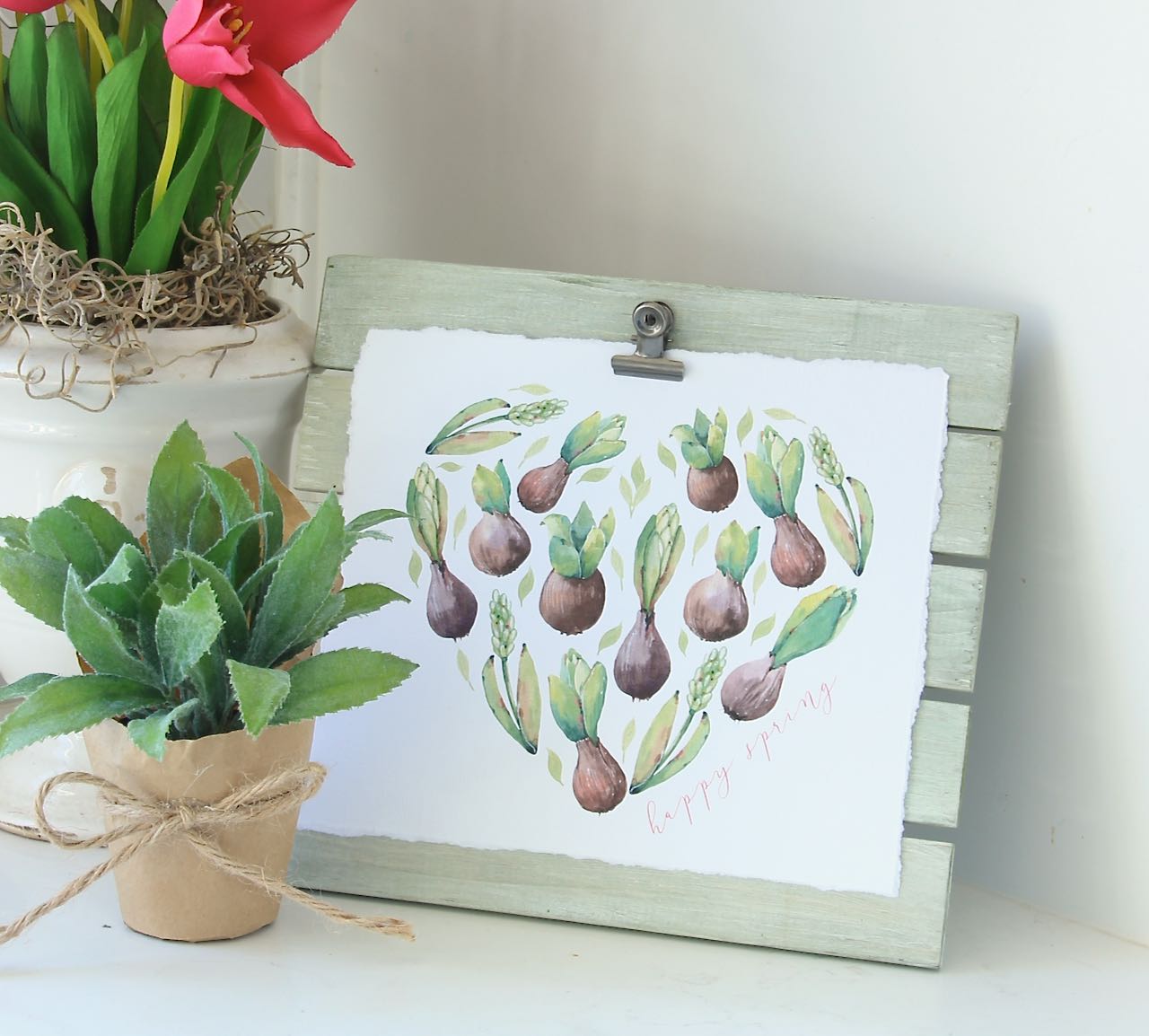 Heart shape filled with sprouting bulbs and leaves on the green washed easel