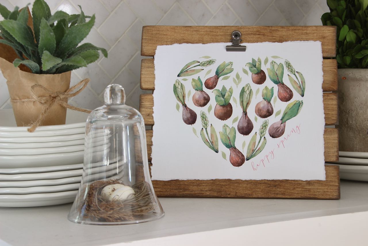 Heart shape made from sprouting bulbs and leaves clipped on a stained easel  on kitchen counter