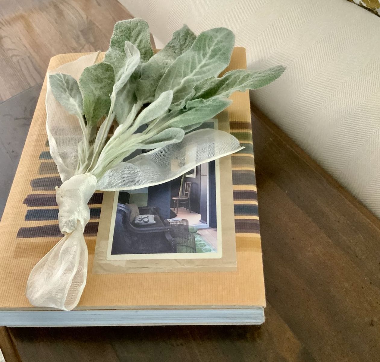 bundle of dried lambs ear tied with ribbon on a book on a sidetable