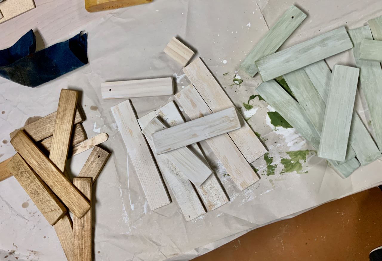 piles of wood pieces, stained brown, whitewashed and pale green