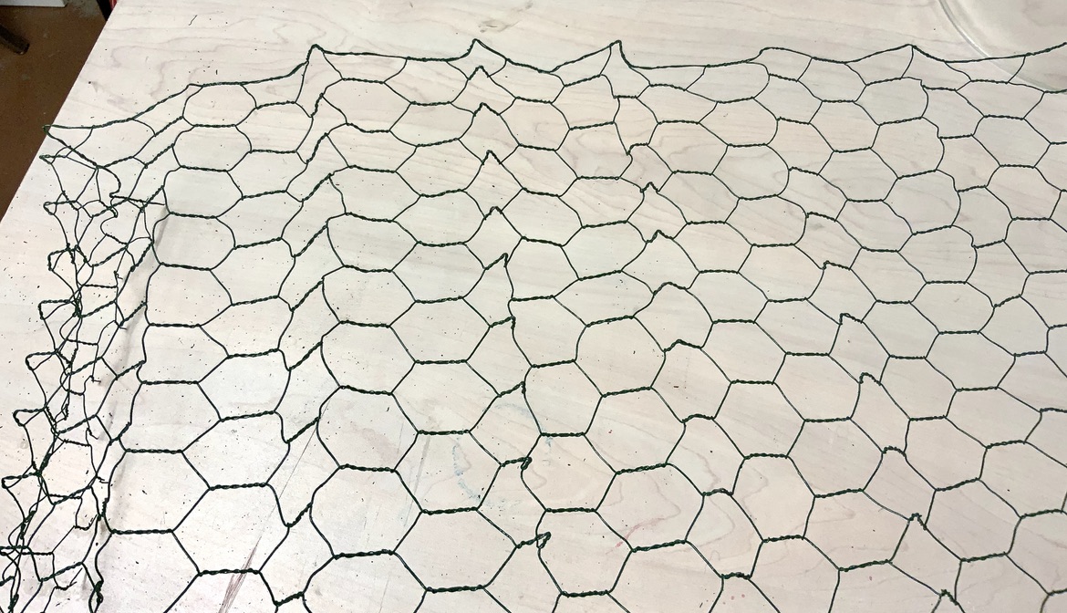Wire mesh unfolded but with crinkles from being folded on work table