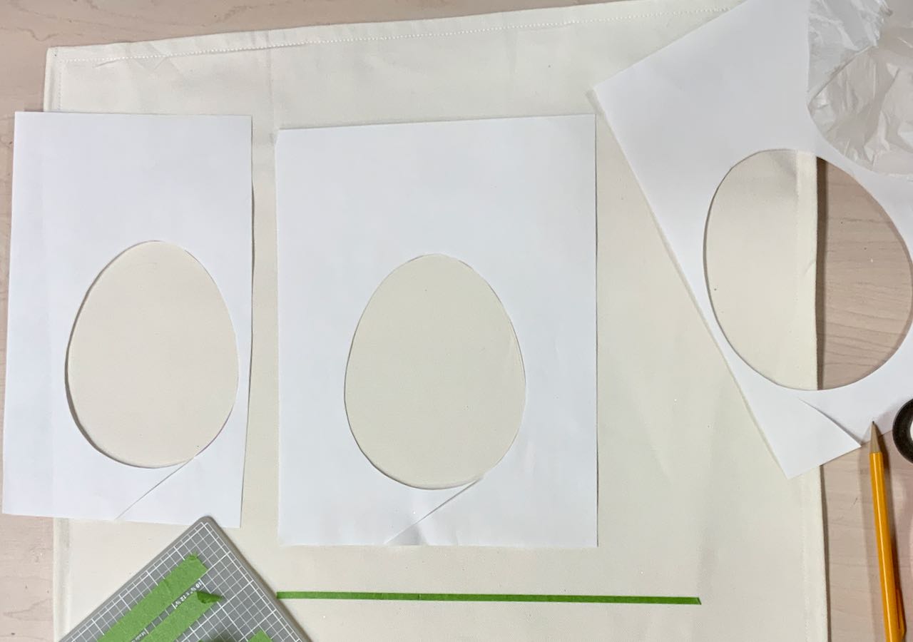 Three pieces of paper with eggs cuts out of them