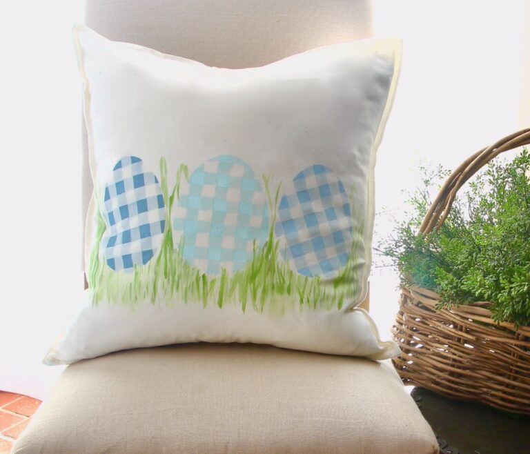 Closeup of pillow with three plaid eggs in tufts of grass