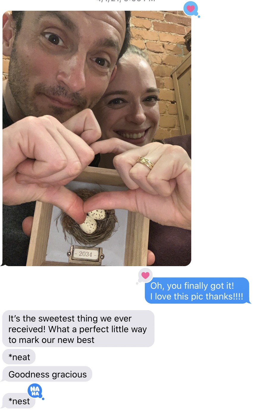 Picture of happy couple making a heart with their hands over the framed nest followed by text message saying "it's the sweetest thing we ever received! What a perfect little way to mark our new nest."