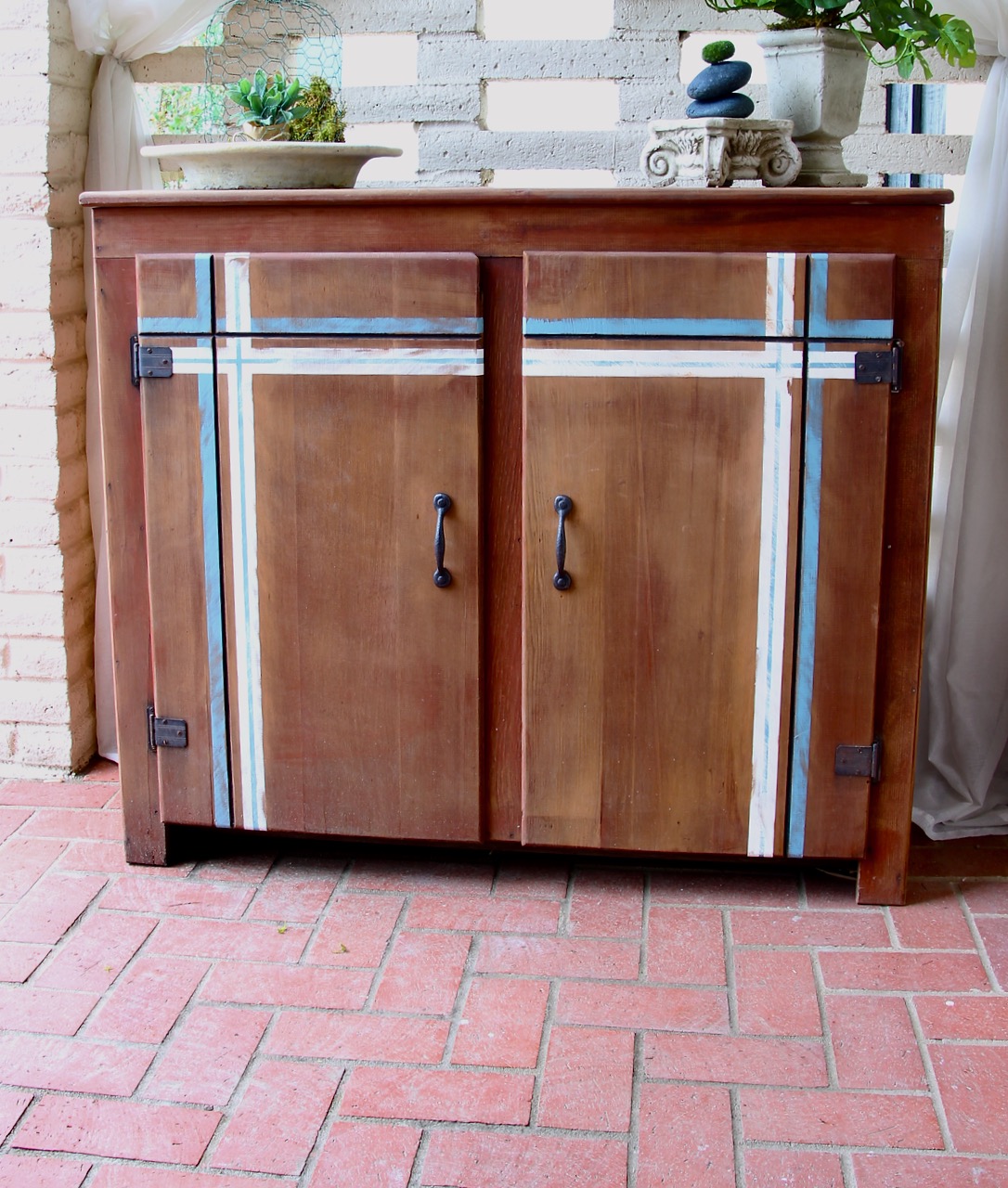 After picture of the finished cabinet with a distressed plaid pattern in blue and white stained stripes.