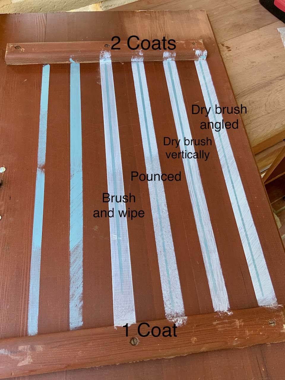 Inside of a cabinet door with six test stripes painted using different methods