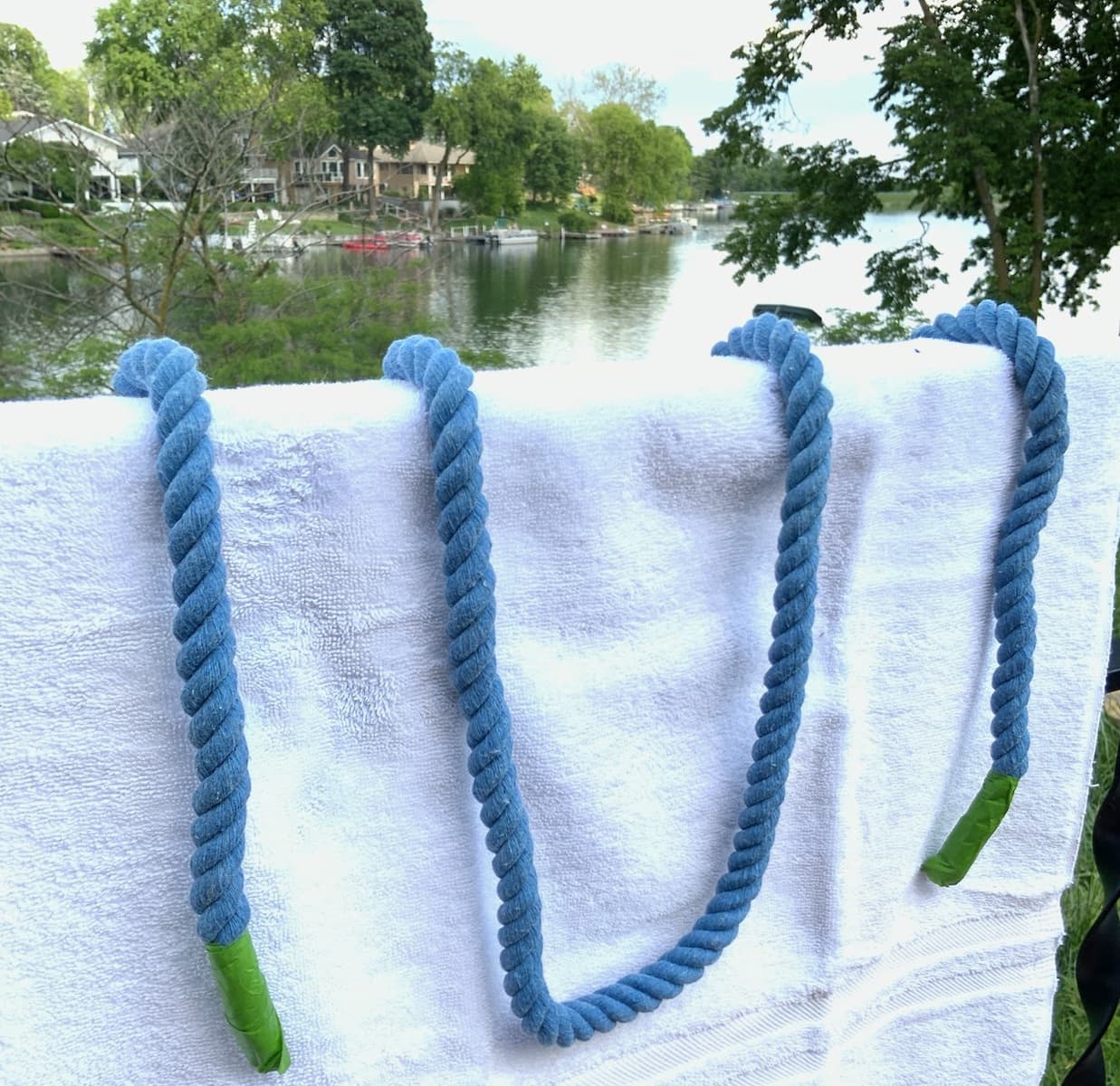 Length of dyed rope looped on a towel  over an outdoor railing