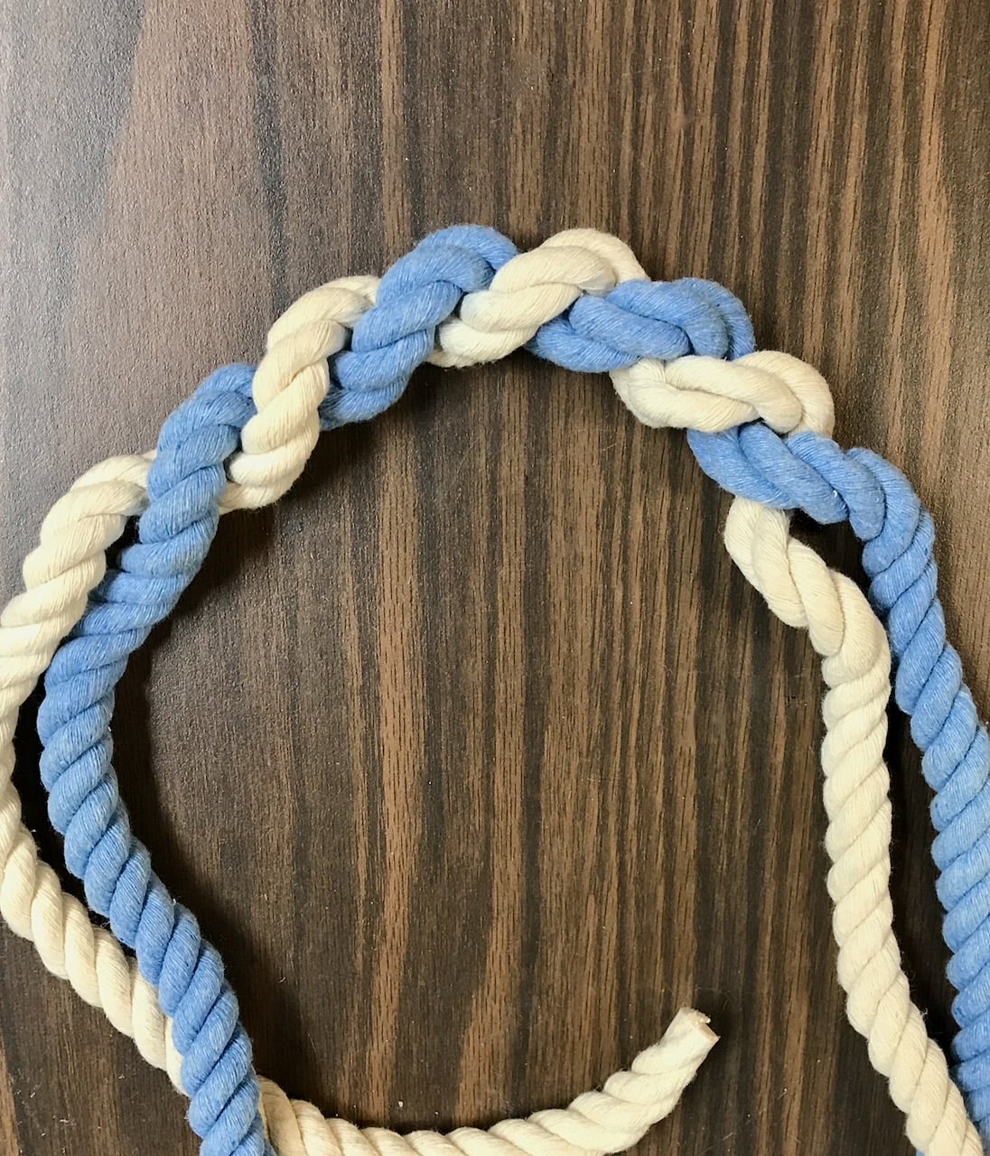 natural and dyed nautical rope twisted together on a dark table top