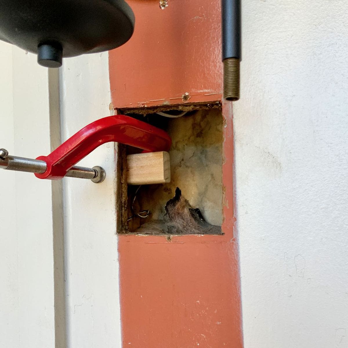 The hole with a short horizontal support board clamped in place 