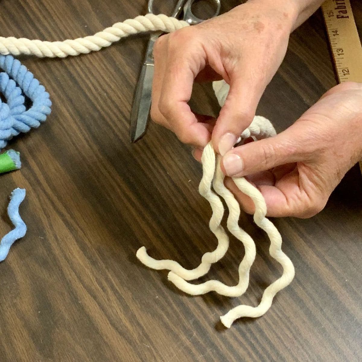 Hand separating the three coils of the natural ropw