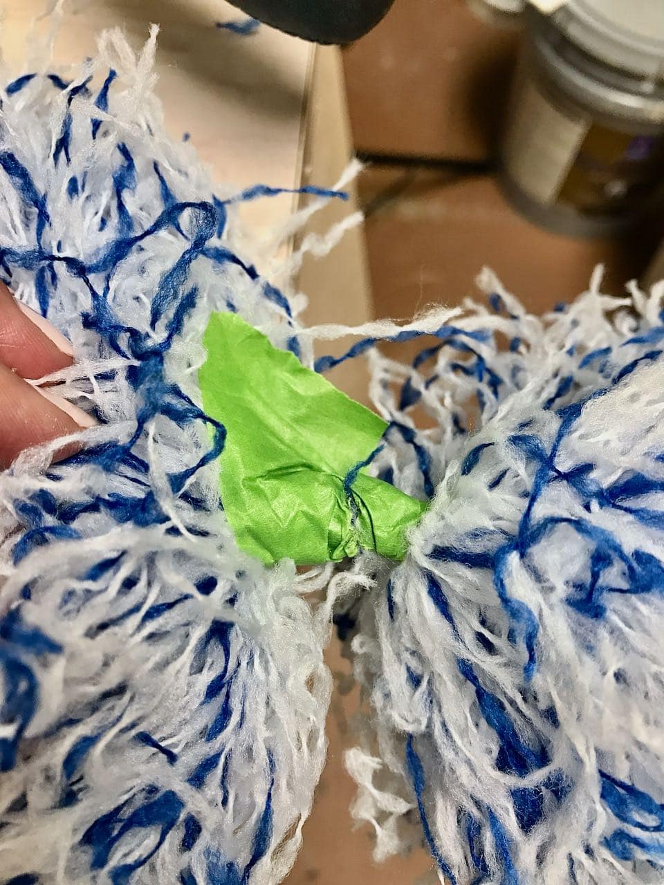 closeup of duster with green painters tape separating the fibers in opposite directions