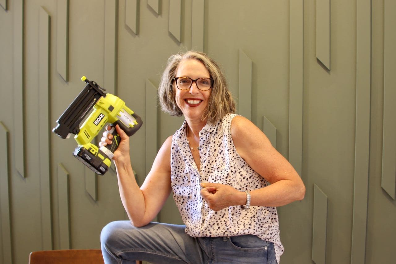 Mom feeling very empowered with her Ryobi nail gun in front of the new accent wall