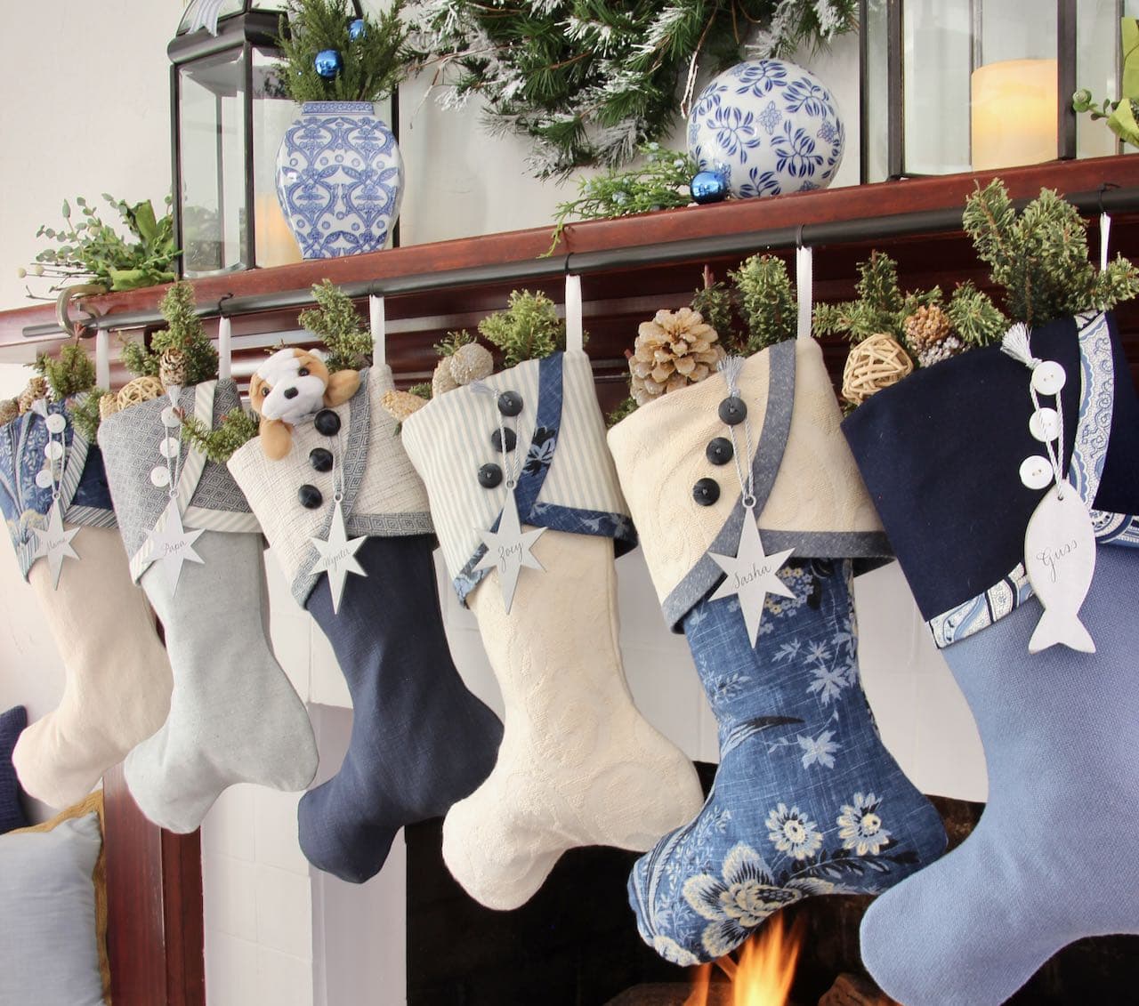 The Blues Christmas Stockings hanging from a dark wood mantel with silver star name tags
