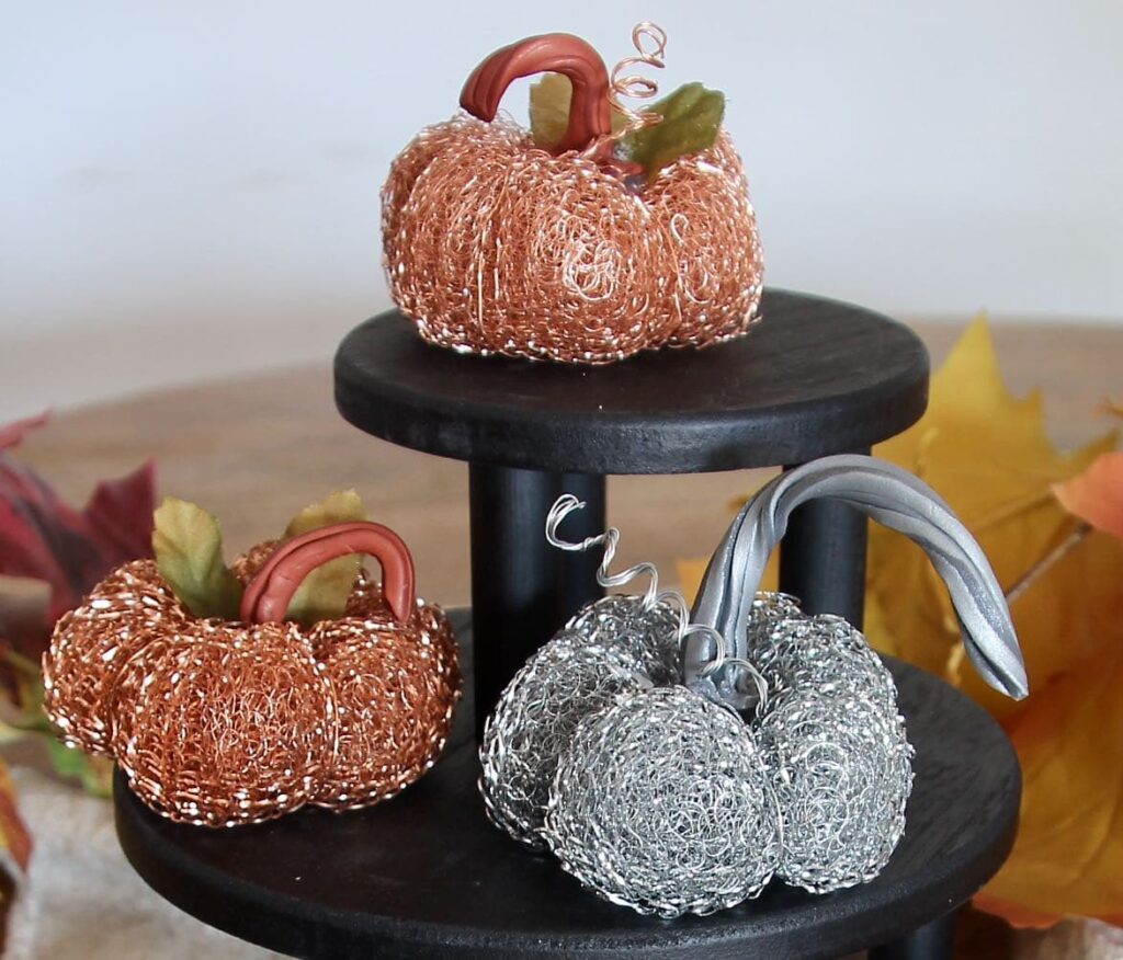 three mini pumpkins of black risers with faux pumpkin stems