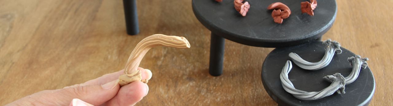 Title Image of fingers holding a faux pumpkin stem made of polymer clay with more stems in the background