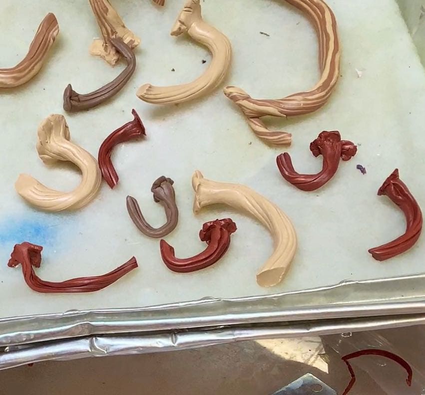 a foil backing dish lined with batting and filled with many prepared faux stems ready to be baked