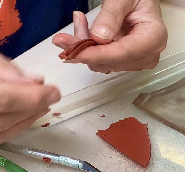 hands manipulating the bundle of polymer clay slices