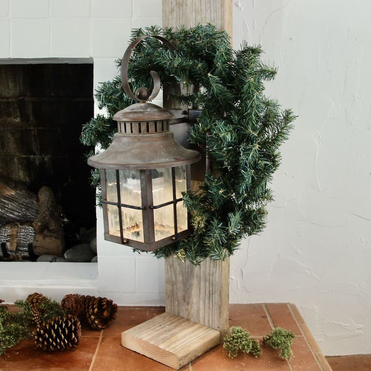 Vintage Lantern on Wood Post with Simple wreath hanging on it.