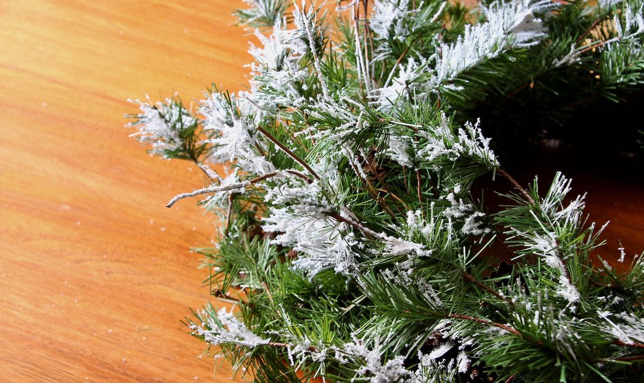 closeup of part of a wreath that has been revived with artificial snow