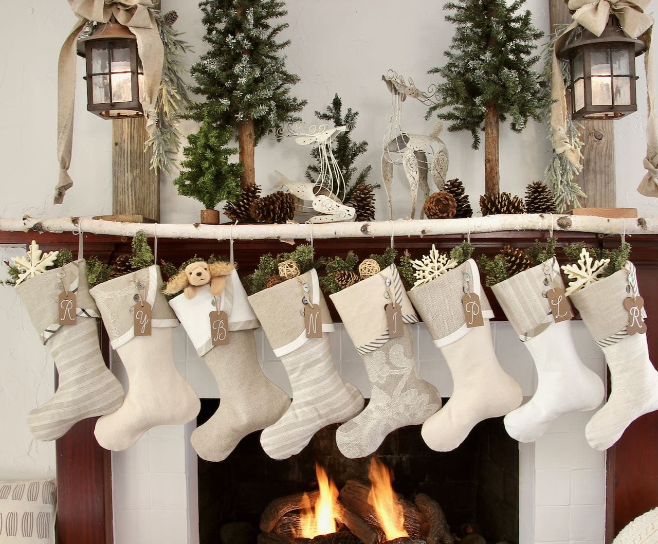 Full view of the finished mantel with 8 Farmhouse Christmas stockings hanging from the birch branch