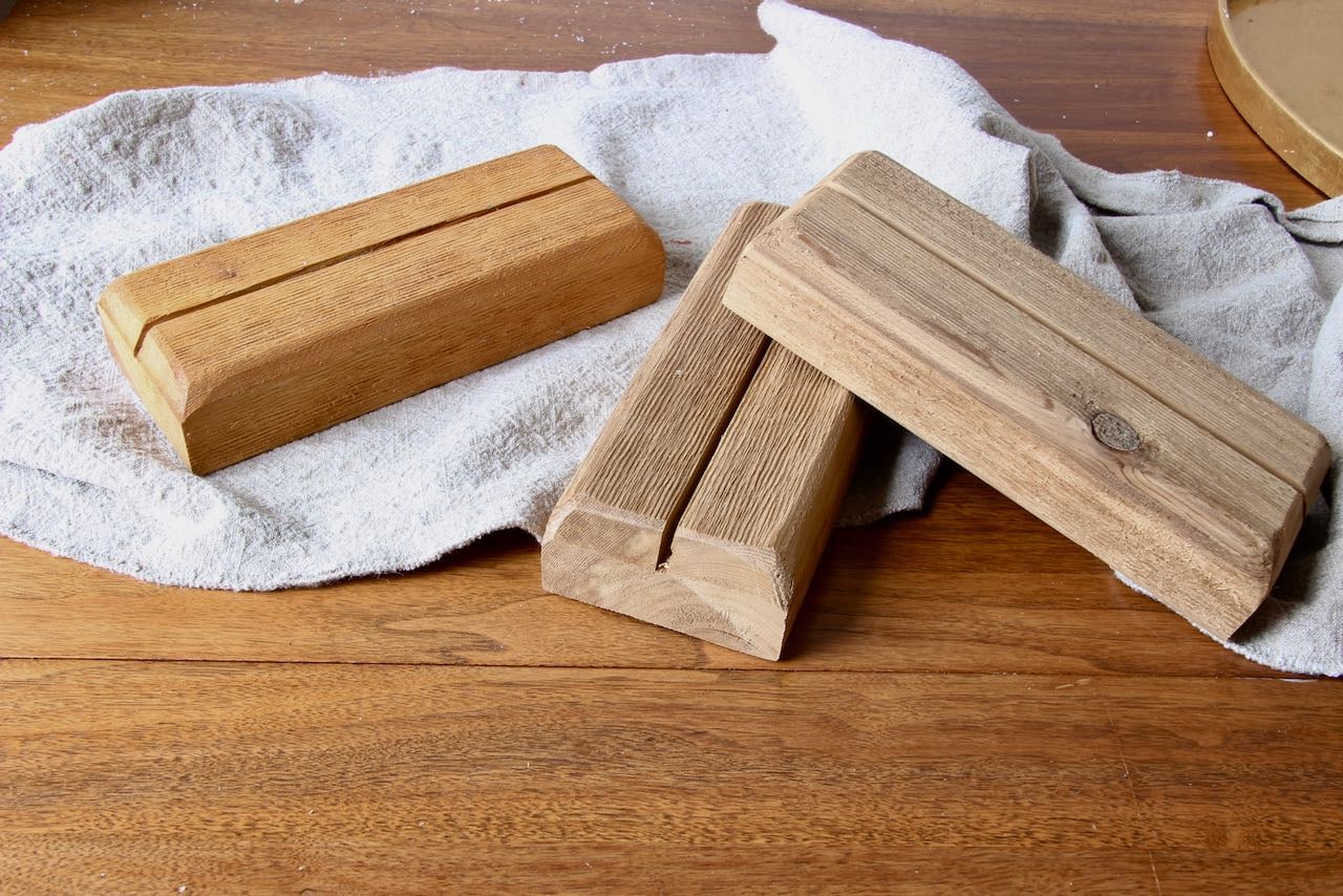 Three wood bases showing closeup of the size, the curved edges and the channel for the blade