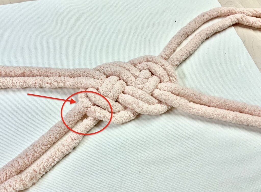 Closeup of double knot laying on pillow cover with an error circle in red