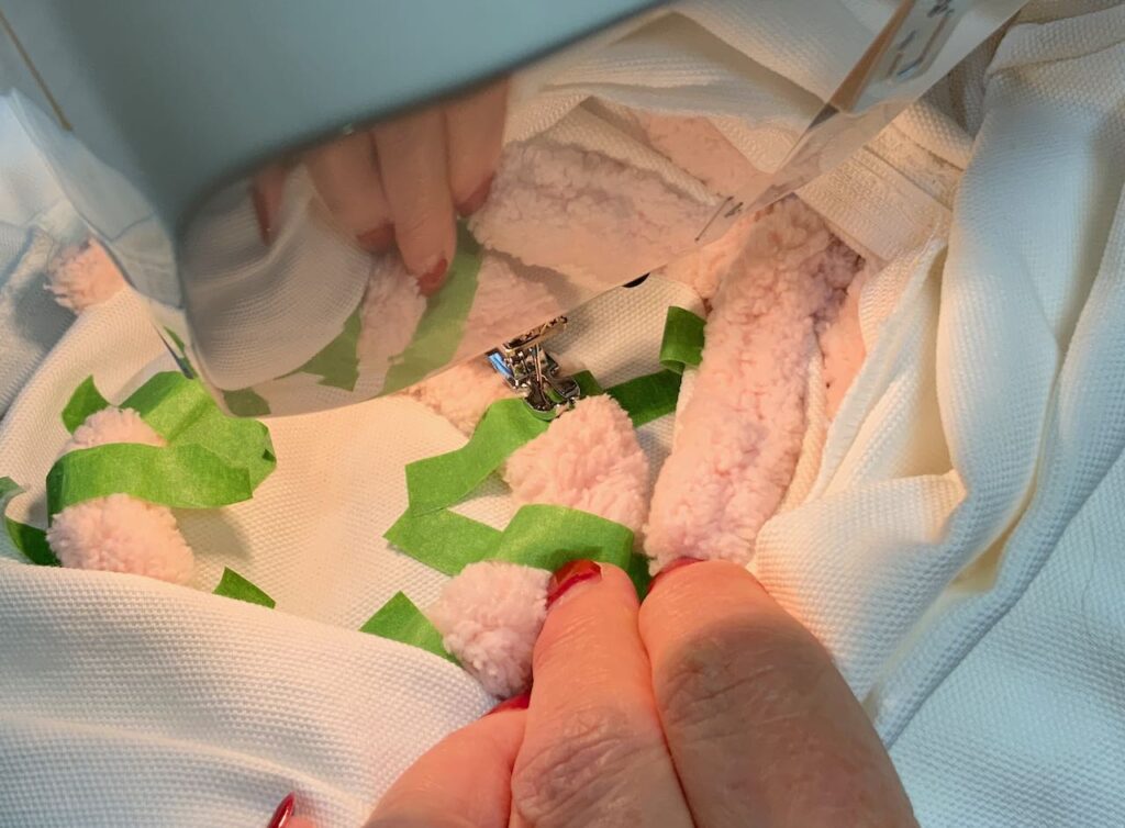 Closeup of sewing machine stitching on an O with the pillow turned right side out around it