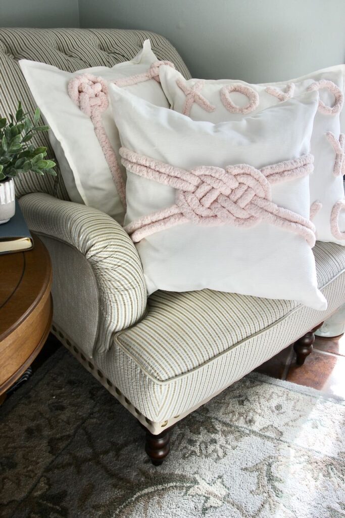 Three Valentines Day pillows piled in a chair