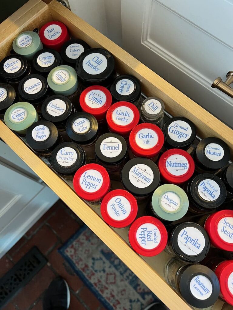 undercounter pullout filled with spice jars with coordinating labels on top of each one. 