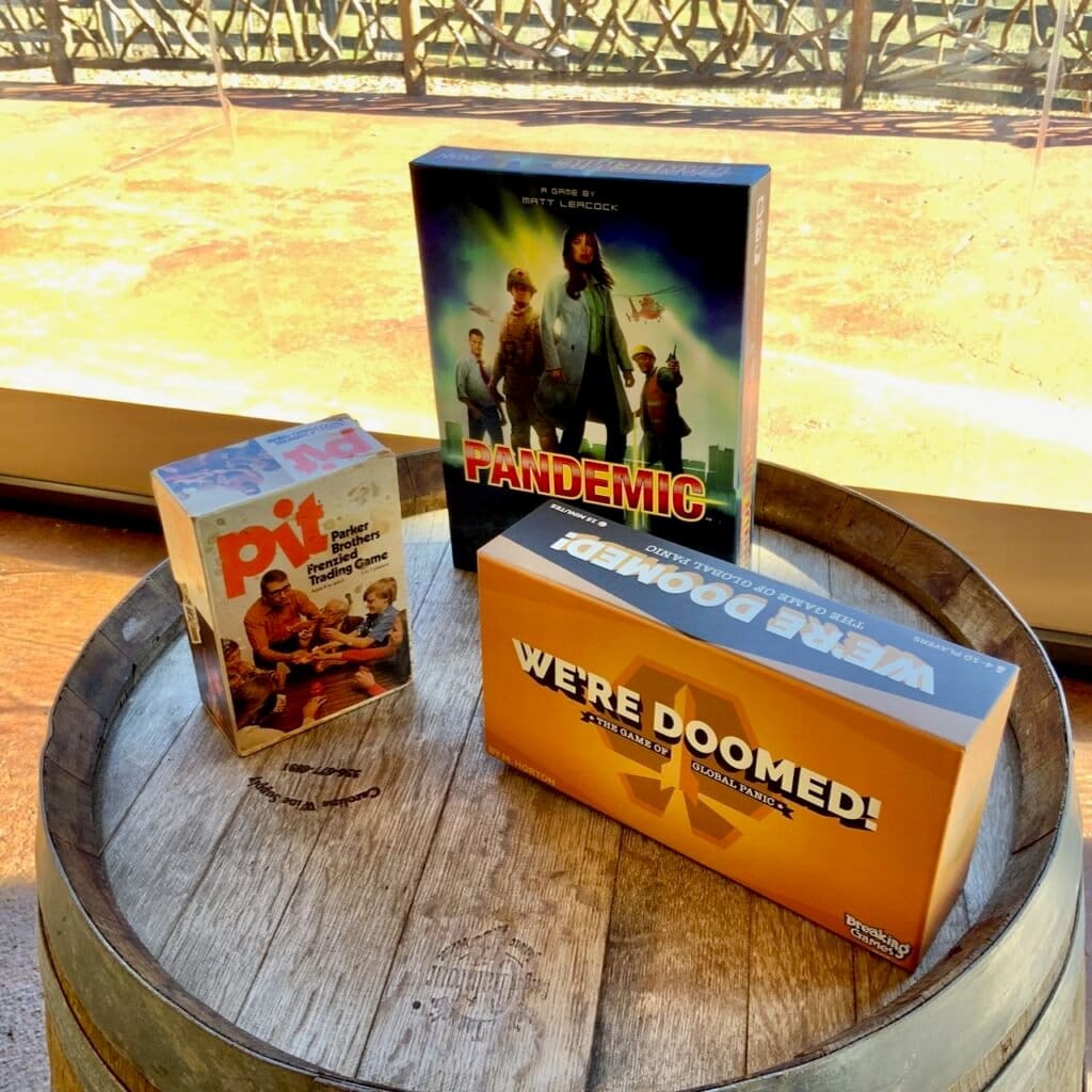 Three board games displayed on top of a wine barrel at Friendsgiving