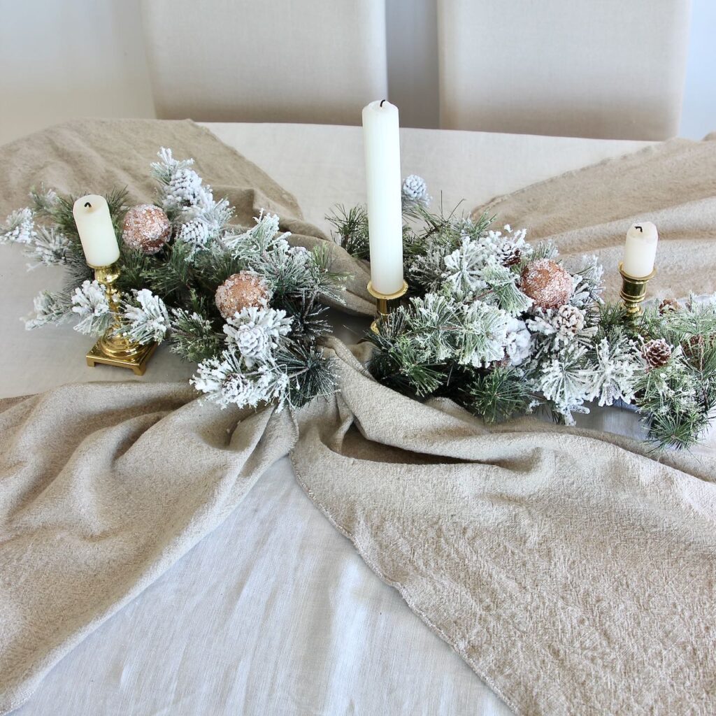 The full centerpiece and runners in view with three brass candlesticks now added with three white candles