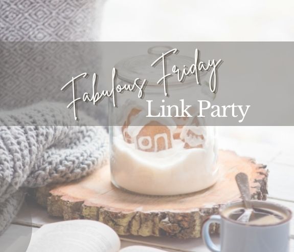 A scene of cozy home accessories - a clear jar of gingerbread house cookies, a mug of coffee, a fuzzy pillow and throw and an open book with an overlay that reads: Fabulous Friday Link Party